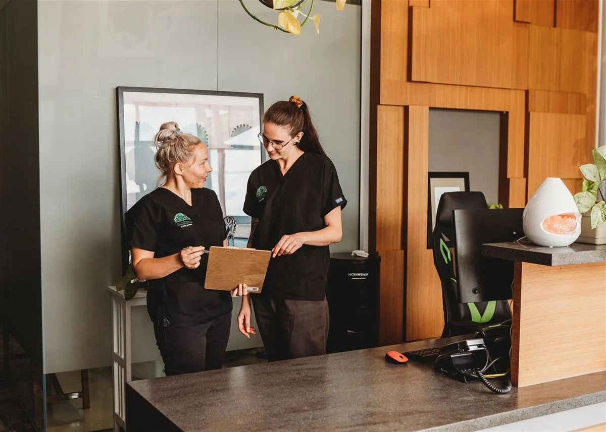 Two Southside Dental Toowoomba team members chatting at the front reception desk
